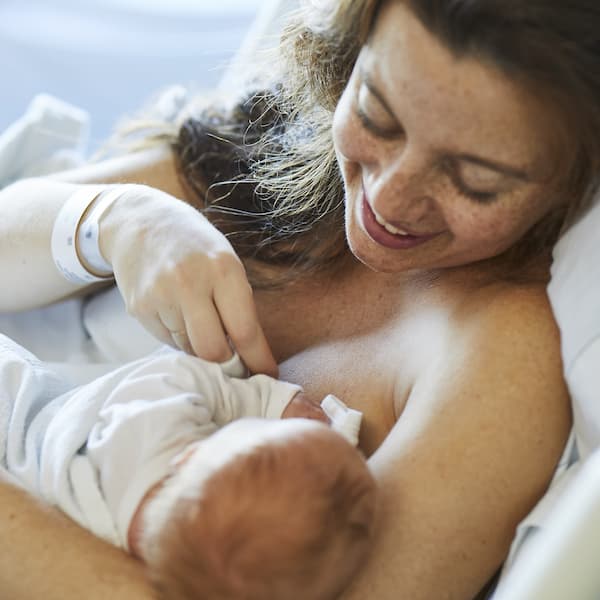 mother nursing a baby in a hospital bed